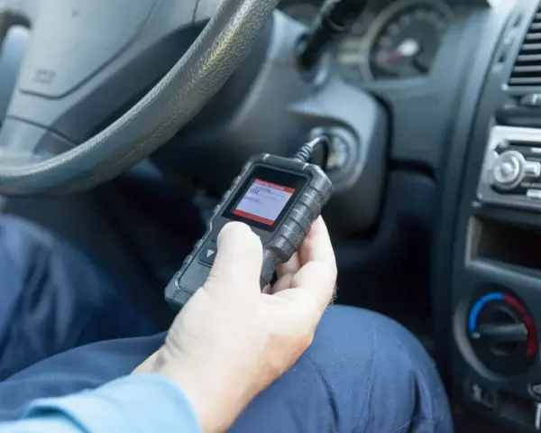 Diagnostyka Opla z kodem DTC U0415. Mechanik sprawdza błędy w samochodzie za pomocą czytnika OBD.