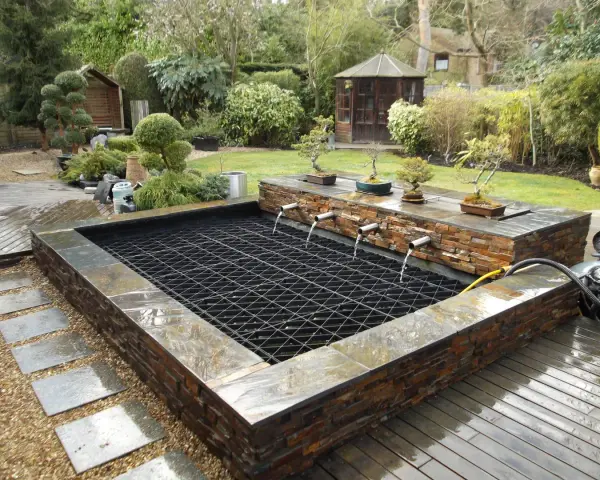 Estanque con cascadas y bonsáis, ideal para recoger agua de lluvia. Un oasis zen en el jardín.