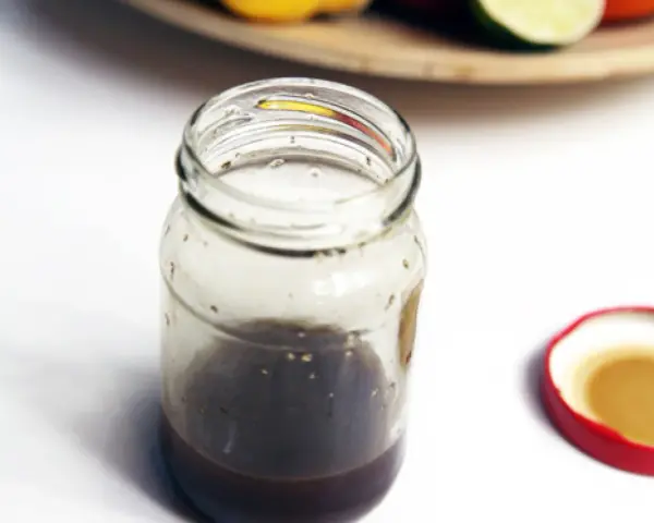 Słoik z domowym sosem balsamicznym i otwartą czerwoną zakrętką.
