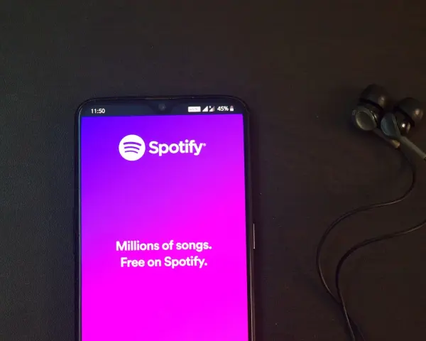 Telefon z aplikacją Spotify i słuchawkami. Idealne do słuchania wzruszających piosenek o przyjaźni.
