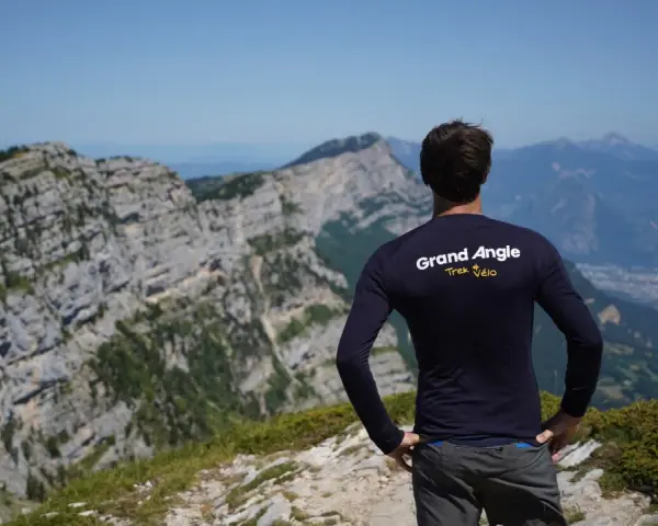Un cycliste admire le panorama après un **tour du Vercors 7 jours**. Le paysage montagneux est spectaculaire.