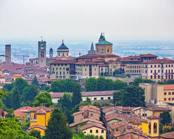 Panorama Bergamo, gdzie zwiedzić warto zabytkowe wieże i kopuły. Miasto zachwyca architekturą i zielenią.