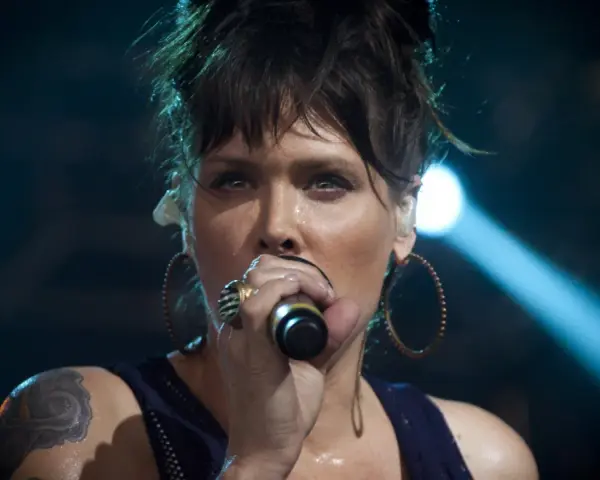 Beth Hart z tatuażem na ramieniu, w okrągłych kolczykach, śpiewa do mikrofonu. Choć nie widać jej dzieci, jej energia na scenie jest jak dla nich.