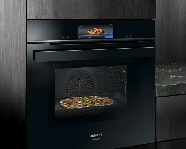 Modern ugn med touchskärm som visar en pizza. Denna Siemens studioline ugn har ångfunktion för perfekt bakning.
