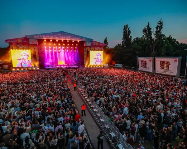 Koncert na Orange Warsaw Festival z tłumem widzów i artystą na telebimie.