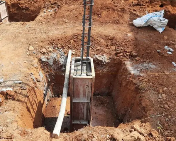 Wykop pod fundament słupowy, zbrojenie i szalunek gotowe do zalania betonem.