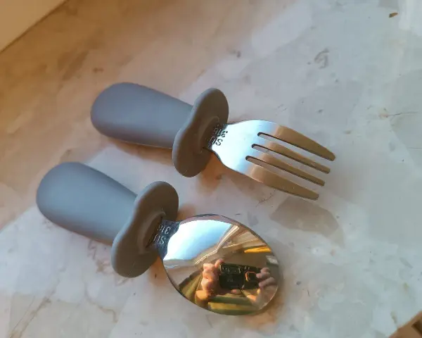 Szare, ergonomiczne pierwsze sztućce dla dzieci: łyżka i widelec. Idealne do nauki samodzielnego jedzenia.