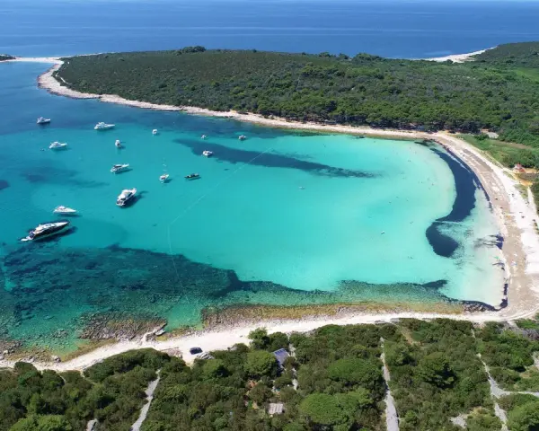 Turkusowa zatoka z łodziami, jedna z najpiękniejszych plaż w Chorwacji.