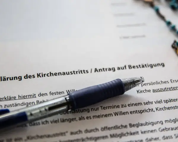 Dokument zur Kirchenaustrittserklärung mit Stift und Rosenkranz. Der Text erwähnt "Kirchensteuer bezahlen", was auf eine mögliche Kirchensteuererstattung hindeutet.