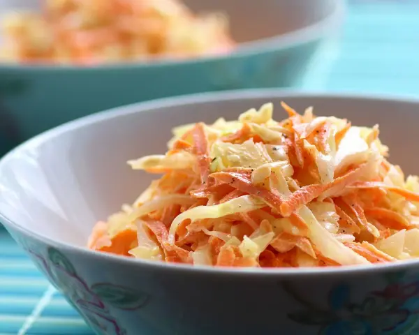 Un bol de véritable sauce coleslaw, mélange frais de chou râpé et de carottes, assaisonné de poivre noir.
