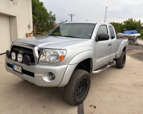 Srebrna Toyota Tacoma z dodatkowymi światłami, gotowa na przygodę.