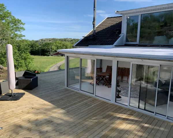 Ny slipad altan med glasveranda och utemöbler. Perfekt för att njuta av sommaren.