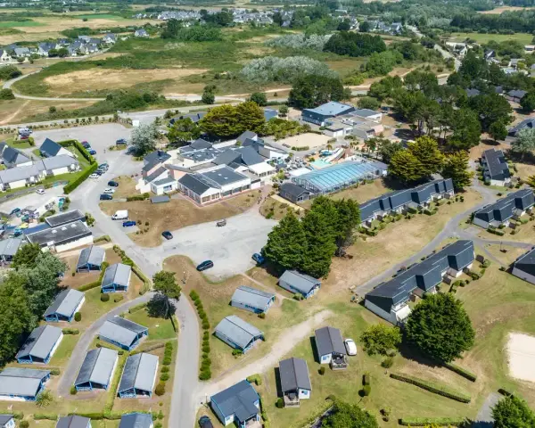 Vue aérienne d'une zone vacances Bretagne avec des maisons, une piscine et des espaces verts.