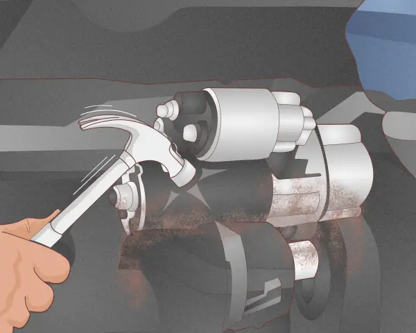 A hand uses a hammer to tap a car's starter motor, a common trick for how to start a car with a bad starter.