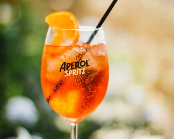 Ett glas Aperol Spritz med is, apelsinskiva och sugrör. Perfekt för en solig dag, vilket sodavatten till aperol spritz?