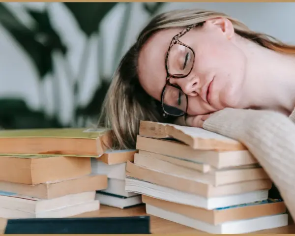 Zmęczona studentka zasnęła na stosie książek, zastanawiając się, psychoza co to.
