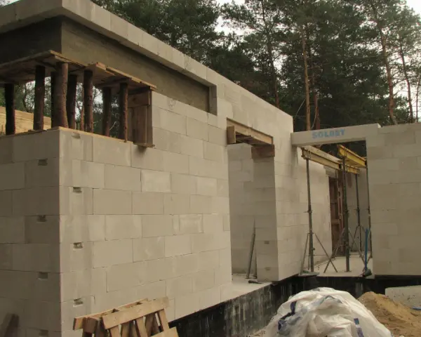 Budowa domu z bloczków betonowych. Widoczny maksymalny otwór bez nadproża, przygotowany do montażu okna lub drzwi.