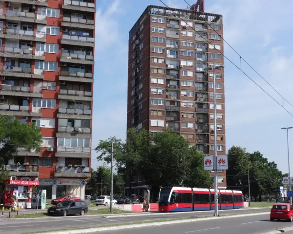Wielopiętrowe budynki mieszkalne i nowoczesny tramwaj na ulicy. Czy w Belgradzie jest bezpiecznie? Wygląda na spokojne miasto.