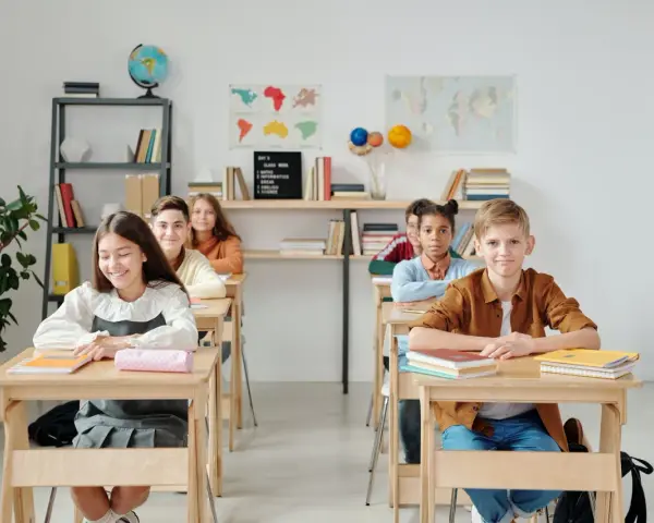 Uczniowie siedzą w ławkach w klasie, która wygląda jak szkoła średnia w Niemczech.