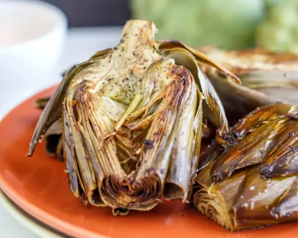 Alcachofas al horno, doradas y tiernas, listas para disfrutar. Un plato sencillo y delicioso.
