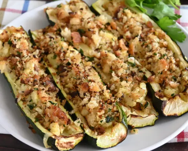 Zucchine ripiene al forno, dorate e croccanti, con un ripieno saporito e erbe aromatiche. Un piatto invitante e gustoso.
