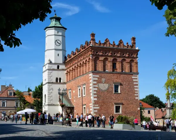 Ratusz w Sandomierzu z zegarem i zegarem słonecznym. Spacerujący ludzie na rynku, ciekawe miejsca Sandomierza.