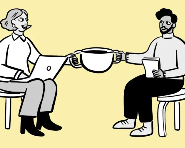 Dos personas sentadas, una con laptop y otra con papeles, comparten una taza de café. Podría ser una reunión para revisar la cuenta contable anticipo acreedores.