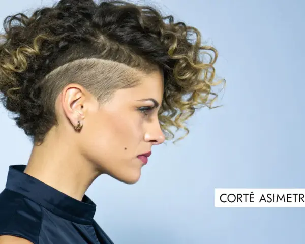 Mujer con pelo corto rizado y rapado asimétrico, luciendo un estilo audaz y moderno.