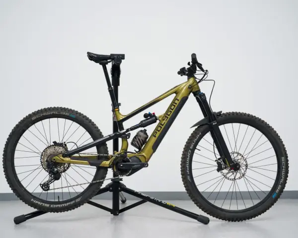 A gold Polygon mullet bike with a dropper post, full suspension, and knobby tires, ready for any trail.