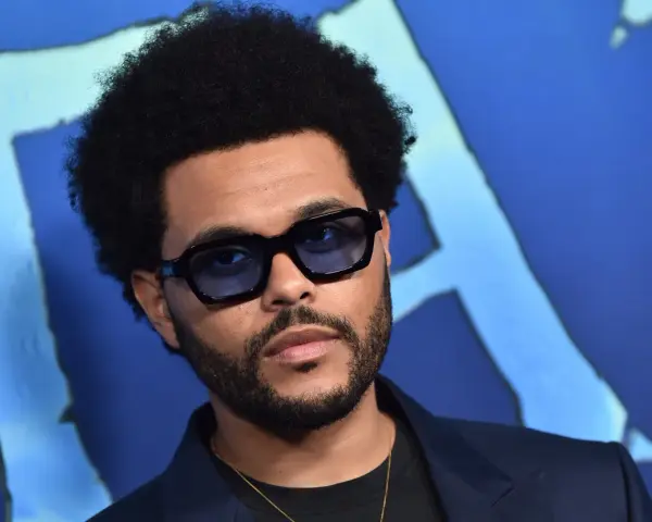 The Weeknd w okularach, z afro i zarostem, na niebieskim tle. Pośpiesz się jutro, bo to jego premiera!