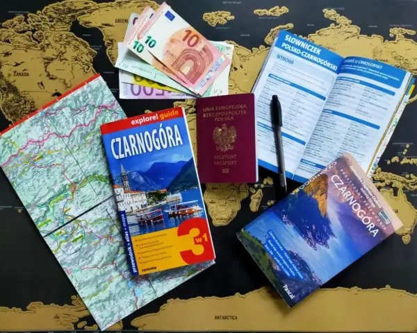 Paszport, pieniądze i przewodniki po Czarnogórze leżą na mapie świata. Czy do Czarnogóry potrzebny jest paszport? Tak, jeśli jesteś obywatelem Polski.