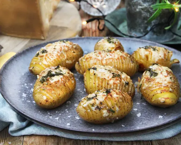Hasselbackspotatis recept: gyllene, krispiga potatisar med ost och örter, redo att avnjutas.