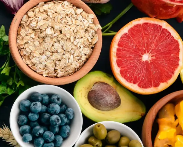 Assortiment de fruits et légumes : flocons d'avoine, myrtilles, avocat, pamplemousse, citron, olives, mangue. Attention aux aliments mauvais pour la flore intestinale.