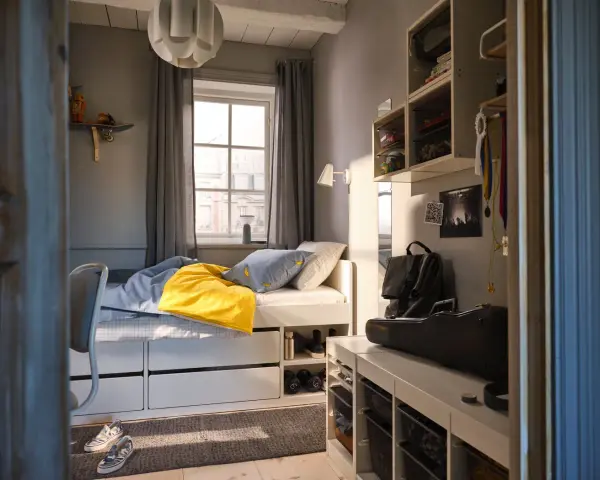 Ett mysigt tonårsrum kille med säng, skrivbord och förvaring. En gul filt och banankudde piggar upp.