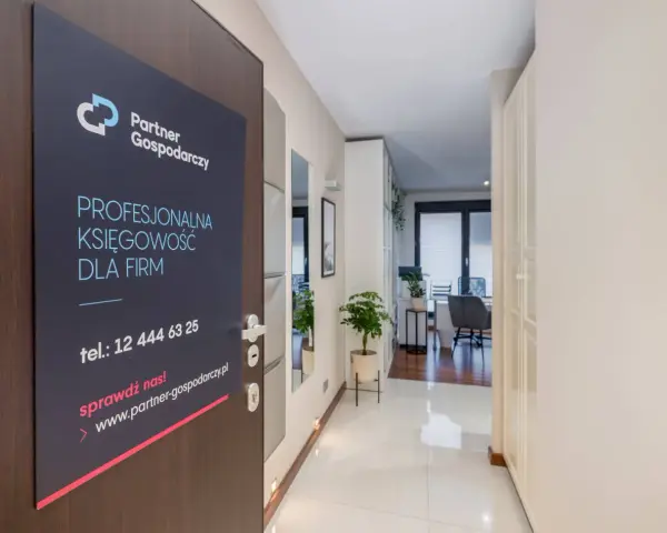 Tabliczka na drzwiach z logo "Partner Gospodarczy" i hasłem "Profesjonalna księgowość dla firm".
