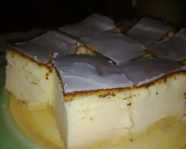 Pokrojony na kwadraty sernik tradycyjny z lukrem, idealny na prosty przepis.
