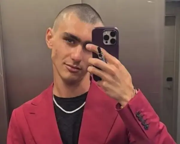 Achille Costacurta, con un look audace e un sorriso enigmatico, sembra affrontare i suoi problemi con stile, sfoggiando un completo fucsia e una collana scintillante.