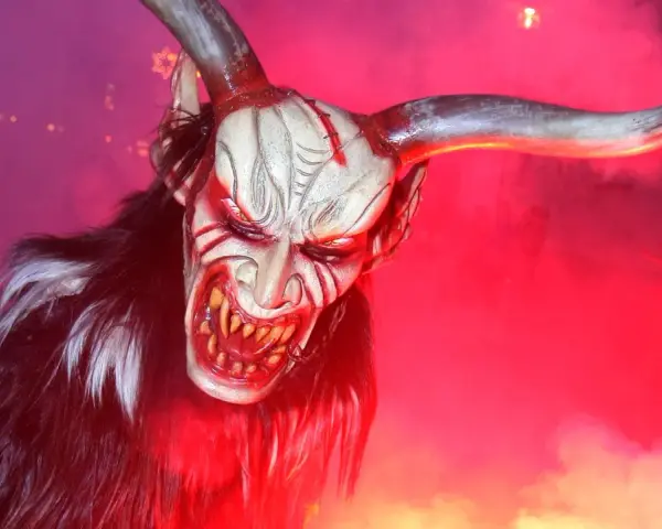 Gruselige Maske eines Teufels mit Hörnern und Fell, die an eine düstere Figur aus der Bibel erinnert.