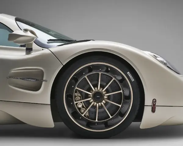 Dettaglio di un'auto sportiva color champagne, con focus sulla ruota e sul pneumatico. La corretta pressione pneumatici auto è fondamentale per prestazioni ottimali.
