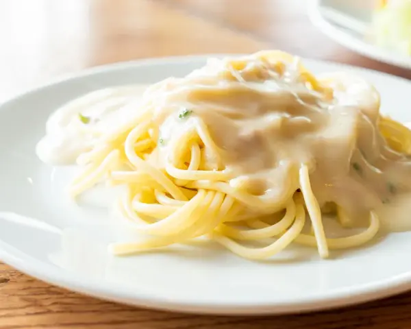 Pyszne spaghetti z kremowym sosem, idealne do podania z parmezanem. Jaki ser do spaghetti wybrać?