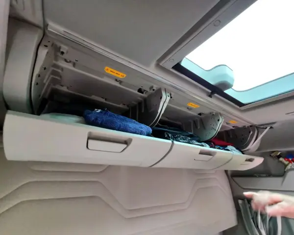 Schowek w kabinie Ford F-Max z niebieskim ręcznikiem i innymi przedmiotami.