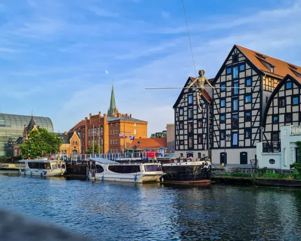 Bydgoszcz atrakcje: Łucznik na linie nad Brdą, nowoczesna architektura i zabytkowe kamienice tworzą malowniczy widok.