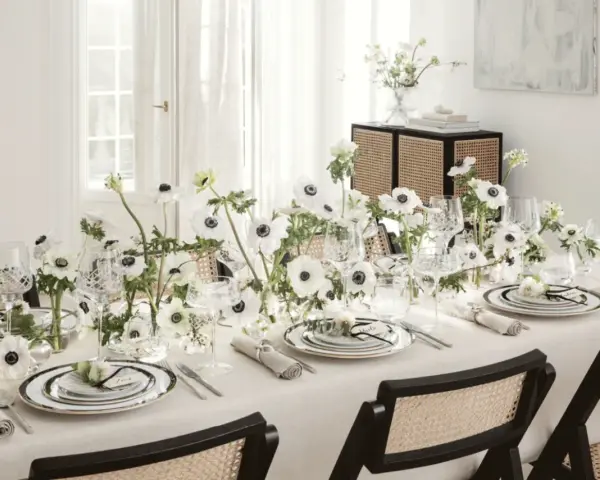 Ett elegant dukat bord med vita anemoneblommor och kristallglas. En diskret detalj är sugrör guld som ger en lyxig touch.
