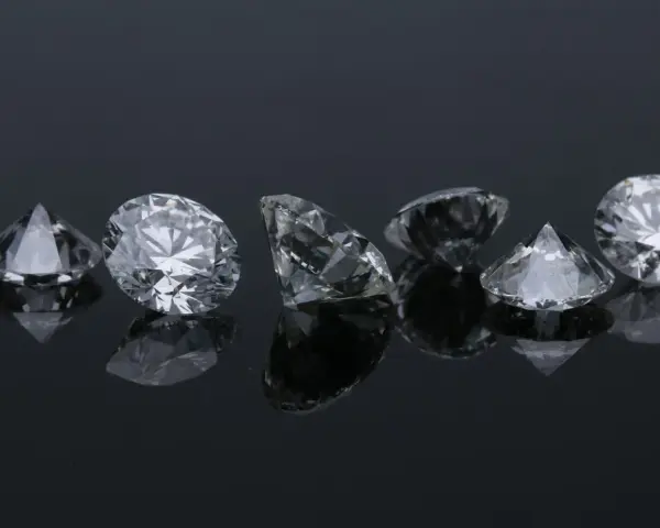 Siedem błyszczących diamentów na czarnym tle. Co oznacza diament na sympatii? Symbol trwałości i piękna, jak te kamienie.
