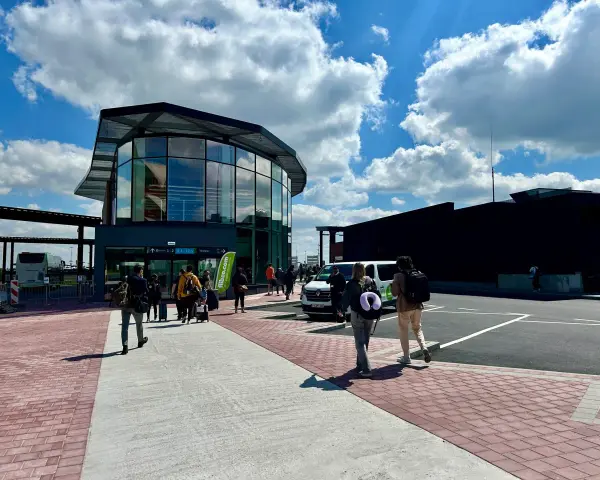 Ludzie z bagażami idą do nowoczesnego terminalu lotniska w Brukseli Charleroi.