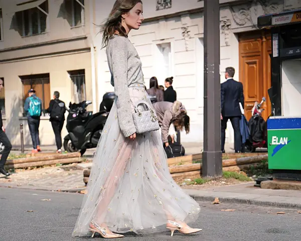 Elegante outfit vestido invierno con falda de tul bordada y jersey gris. Bolso Dior y zapatos de tacón completan el look.