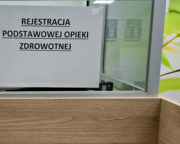 Tabliczka "Rejestracja Podstawowej Opieki Zdrowotnej" w poczekalni. Ubezpieczenie zdrowotne to podstawa.