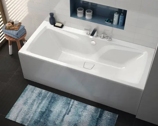 Baignoire blanche moderne, d'une largeur baignoire standard, avec robinetterie chromée et étagère murale.