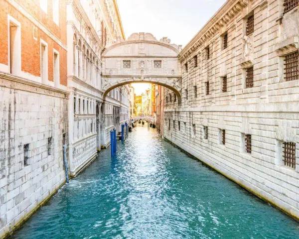 Il Ponte dei Sospiri a Venezia, con la sua leggenda di condanne e addii, si staglia maestoso sul canale azzurro.
