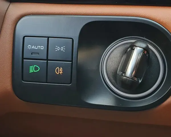 Przycisk z pomarańczową ikoną mgły to jak włączyć światła przeciwmgielne. Obok przycisk AUTO i świateł drogowych.